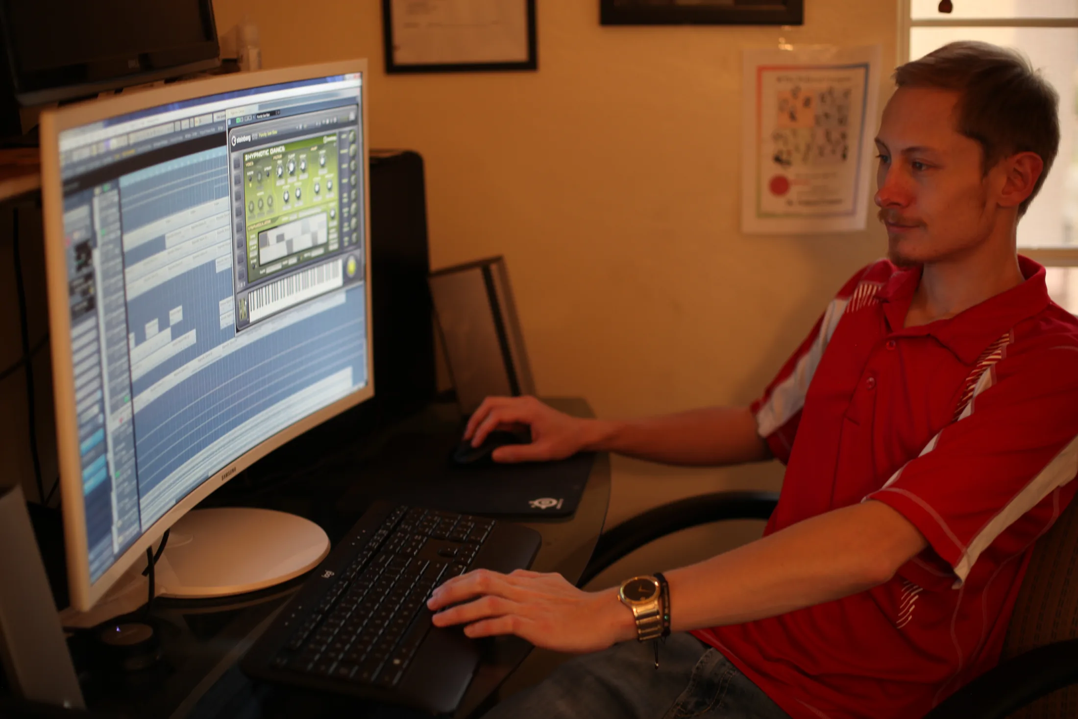 Ryan working in Cubase at a home studio desk with reference pages taped to the wall